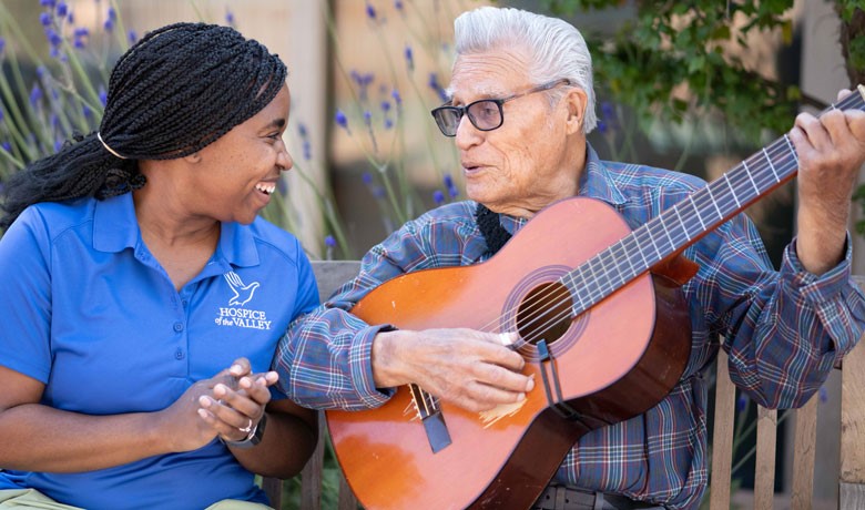 Dementia patient playing guitar with nurse