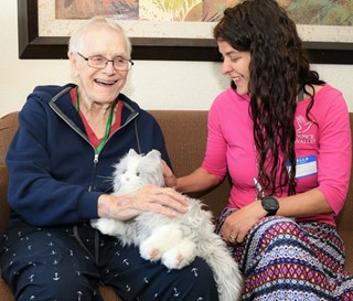 Social worker Michelle Bales visit with patient Walter “Wally” Brown with mechanical cat