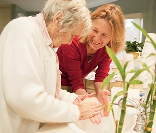 Gillian Hamilton, MD, helps a dementia patient wash her hands