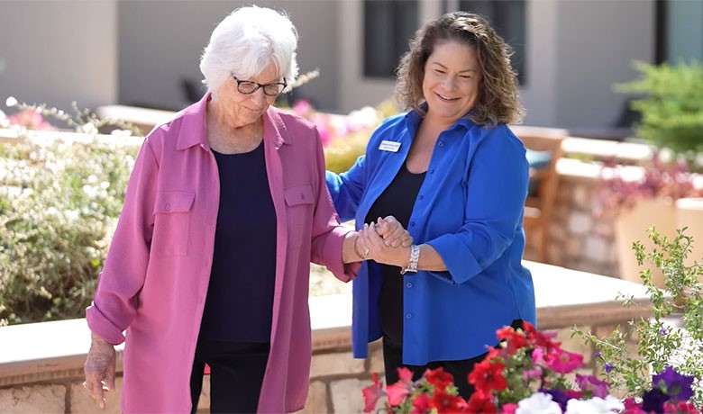 Caretaker walking along side a female dementia patient
