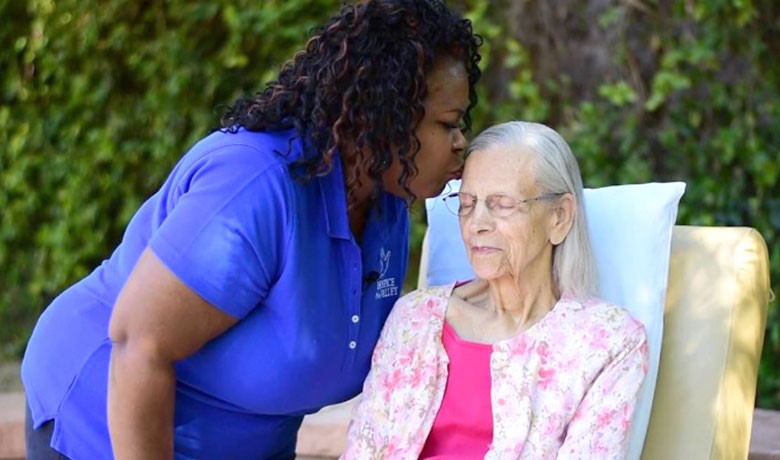 RN Lisa Abatan kissing patient forehead